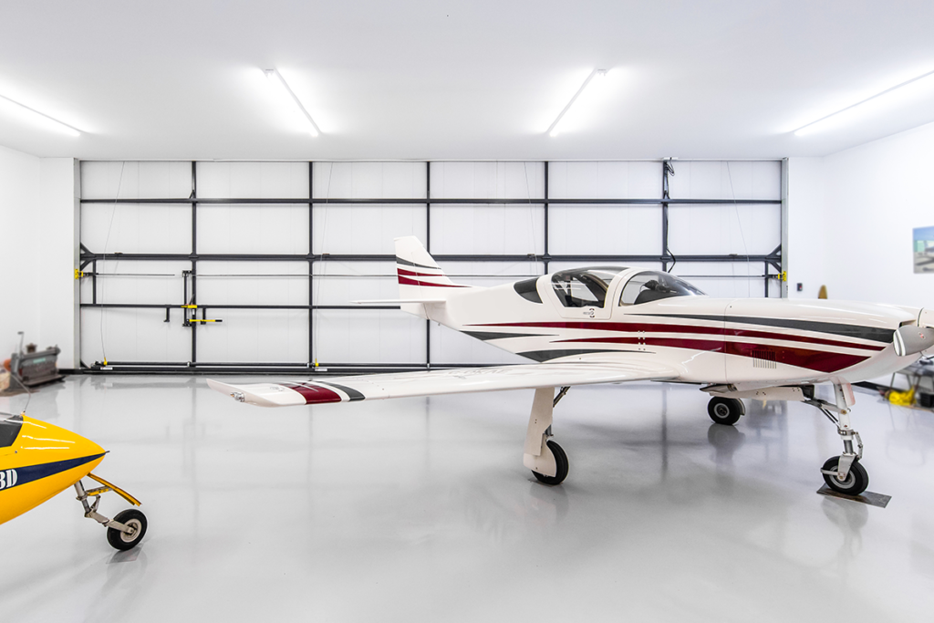 white insulated hangar door and aircraft