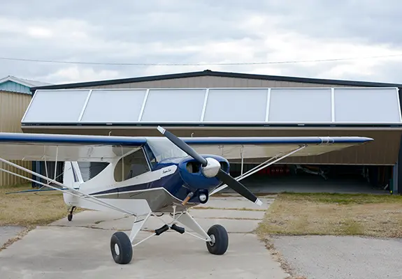 Super Cub in front of a Aviation Bifold door by Diamond Doors